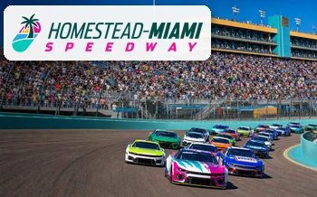 Stock cars racing before a packed grandstand at Homestead–Miami Speedway in Homestead, Florida.
